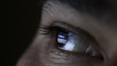 A picture illustration shows a man looking at the Facebook website on a tablet in Sofia