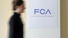 A woman walks past a logo of Fiat Chrysler Automobiles (FCA) in Turin March 31, 2014.  REUTERS/Giorgio Perottino  