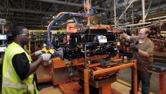 Ford Assembly workers install a battery onto the chassis of a Ford Focus Electric vehicle at the Michigan Assembly Plant in Wayne, Michigan, November 7, 2012.   REUTERS/Rebecca Cook  