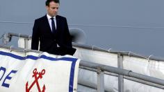 French President Emmanuel Macron heads down the gangway of the French war ship Dixmude docked in the French Navy base of Toulon