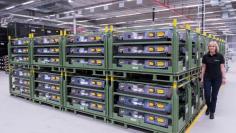 FILE PHOTO: A employee walks along a battery storage in battery factory at Daimler subsidiary ACCUMOTIVE in Kamenz, Germany May 22, 2017. REUTERS/Matthias Rietschel/File Photo           