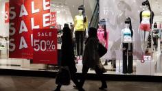 FILE PHOTO - Pedestrians walk past a store window advertising up to 50 percent discount during winter sales in Berlin, January 9, 2014, REUTERS/Fabrizio Bensch