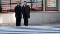 Pedestrians walk past an electronic board displaying the Nikkei average outside a brokerage in Tokyo, Japan January 4, 2018. REUTERS/Kim Kyung-Hoon 