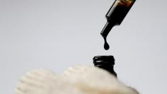 FILE PHOTO: Crude oil is dispensed into a bottle in this illustration photo June 1, 2017.     REUTERS/Thomas White/Illustration/File Photo
