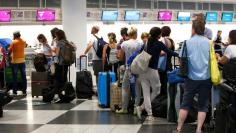 FILE PHOTO: People queue to check in at Munich airport, Germany August 3, 2017.  REUTERS/Michaela Rehle