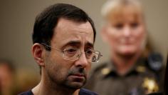 FILE PHOTO:    Larry Nassar, a former team USA Gymnastics doctor who pleaded guilty in November 2017 to sexual assault charges, stands with his legal team during his sentencing hearing in Lansing, Michigan, U.S., January 24, 2018. REUTERS/Brendan McDermi