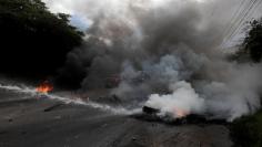 A police water cannon extinguishes burning tires set alight by opposition supporters during a protest over a contested presidential election with allegations of electoral fraud in Tegucigalpa, Honduras, December 22, 2017. REUTERS/Jorge Cabrera