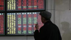 An investor looks at information displayed on an electronic screen at a brokerage house in Shanghai, November 17, 2014. REUTERS/Aly Song  