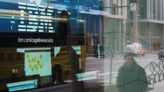 FILE PHOTO: Pedestrians pass a video advertisement for IBM at their office in Cambridge, Massachusetts, U.S., January 16, 2018.   REUTERS/Brian Snyder