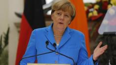 German Chancellor Merkel gestures as she reads a joint statement next to India’s Prime Minister Modi after their delegation-level talks at Hyderabad House in New Delhi