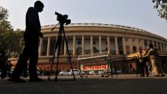 FILE PHOTO: Television journalists report from the premises of India's Parliament in New Delhi