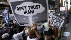 A man holds up a sign as he and several thousand other protestors demonstrate during a rally apposing the nuclear deal with Iran in Times Square in the Manhattan borough of New York City, July 22, 2015. REUTERS/Mike Segar