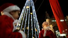 FILE PHOTO: Boys wearing Santa Claus costumes are carried during a Christmas tree lighting ceremony in Nazareth