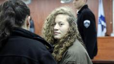 Palestinian teen Ahed Tamimi (R) enters a military courtroom escorted by Israeli Prison Service personnel at Ofer Prison, near the West Bank city of Ramallah, January 1, 2018. REUTERS/Ammar Awad