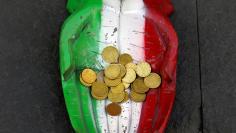 FILE PHOTO: Euro coins are seen on the figure of a pair of hands, which are painted in Italy's national colours. Picture taken on August 23, 2014. REUTERS/Stefano Rellandini/File Photo