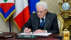 FILE PHOTO: Italian President Sergio Mattarella signs a decree to dissolve parliament at the Quirinale Presidential palace in Rome, Italy, December 28, 2017. Presidential Press Office/Handout via Reuters