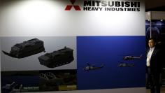 Visitor is seen at Mitsubishi Heavy Industries' booth during the MAST show in Chiba