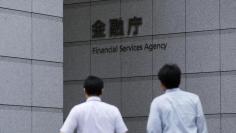 Men walk toward a sign of Japan's Financial Services Agency in Tokyo August 7, 2014.  REUTERS/Toru Hanai  