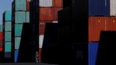 FILE PHOTO: A worker walks in a container area at a port in Tokyo, Japan January 25, 2016. REUTERS/Toru Hanai/File photo
