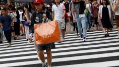 A woman carries a shopping bag at a shopping district in Tokyo, Japan August 14, 2017.   REUTERS/Kim Kyung-Hoon  