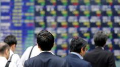 FILE PHOTO: People walk past an electronic stock quotation board outside a brokerage in Tokyo, Japan, September 22, 2017.   REUTERS/Toru Hanai/File Photo