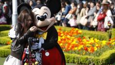 FILE PHOTO: A visitor reacts as she hugs Disney character Mickey Mouse at Tokyo Disneyland in Urayasu, east of Tokyo April 15, 2011. REUTERS/Issei Kato 