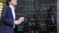 Workers are reflected in the windows of the Canary Wharf offices of JP Morgan in London September 19, 2013. REUTERS/Neil Hall