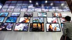 FILE PHOTO -  A visitor takes photos of TV sets made with LG Display flat screens at an exhibition in Goyang, north of Seoul, October 15, 2009.   REUTERS/Lee Jae-Won/File Photo   