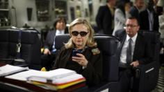 U.S. Secretary of State Hillary Clinton checks her PDA upon her departure in a military C-17 plane from Malta bound for Tripoli,  Libya October 18, 2011. 
REUTERS/Kevin Lamarque 