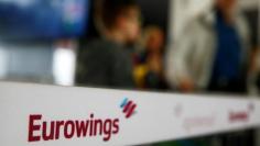 FILE PHOTO - People line up behind a barrier tape of Lufthansa's budget airlines Eurowings during a 24-hour strike over pay and working conditions at Cologne-Bonn airport, Germany October 27, 2016.   REUTERS/Wolfgang Rattay 