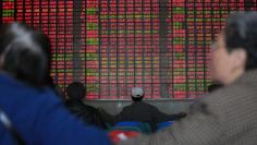 Investors look on in front of an electronic board showing stock information at a brokerage house in Shanghai March 17, 2015. REUTERS/Aly Song 