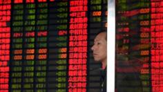 An investor stands in front of an electronic board showing stock information at a brokerage house in Shanghai, China, September 2, 2015.  REUTERS/China Daily 