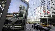 An advertising board (L) showing a Chinese stone lion is pictured near an entrance to the headquarters (R) of China Securities Regulatory Commission (CSRC), in Beijing, China, September 7, 2015.  REUTERS/Jason Lee 