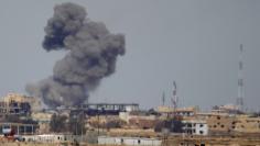 A plume of smoke rises above a building during an air strike in Tikrit March 27, 2015. REUTERS/Thaier Al-Sudani 