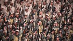 Fighters from the self-defence forces of the Kurdish-led north hold their weapons during a rally in Hasaka