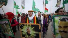 A woman holds a picture of Kurdish leader Abdullah Ocalan of the Kurdistan Workers Party (PKK) during a protest against Turkish attacks on Afrin, in Hasaka province, Syria, January 18, 2018. REUTERS/Rodi Said