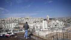 A labourer stands on an apartment building under construction in a Jewish settlement known to Israelis as Har Homa and to Palestinians as Jabal Abu Ghneim, in an area of the West Bank that Israel captured in a 1967 war and annexed to the city of Jerusalem