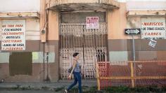 A woman walks past a closed restaurant in Ponce, on Puerto Rico's southern coast, February 5, 2014. REUTERS/Alvin Baez