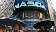 Commuters pass by the NASDAQ Marketsite in New York, May 21, 2012.    REUTERS/Brendan McDermid (UNITED STATES - Tags: BUSINESS)