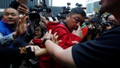 An unidentified man is grabbed by pro-democracy protesters  inside civic square at the government headquarters in Hong Kong