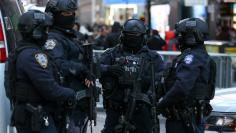 New York Police Department Counterterrorism Bureau members stand in Times Square to provide security ahead of New Year's Eve celebrations in New York