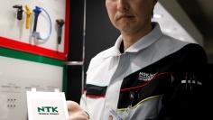 Hideaki Hikosaka, a member of NGK Spark Plug's solid-state battery R&D team, shows a prototype of its all solid-state battery under development during an interview with Reuters in Nagoya, Japan