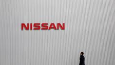 FILE PHOTO: A man walks under the logo of Nissan Motor Co at the company's showroom in Yokohama, south of Tokyo February 8, 2013.   REUTERS/Toru Hanai/File Photo