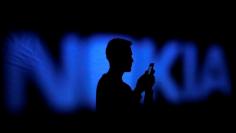 FILE PHOTO: A photo illustration of a man silhouetted against a Nokia logo in the central Bosnian town of Zenica January 23, 2014.      REUTERS/Dado Ruvic/File Photo