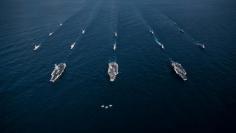 Three F/A-18E Super Hornets fly in formation over the aircraft carriers USS Ronald Reagan USS Theodore Roosevelt USS Nimitz and their strike groups along with ships from the Republic of Korea in the Western Pacific