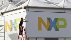 FILE PHOTO: A man works on a tent for NXP Semiconductors in preparation for the 2015 International Consumer Electronics Show (CES) at Las Vegas Convention Center in Las Vegas, Nevada, U.S. on January 4, 2015.   REUTERS/Steve Marcus/File Photo