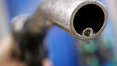 A motorist holds a fuel pump at a Gulf petrol station in London April 18, 2006.  REUTERS/Luke MacGregor/File Photo