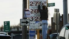 A man changes the price for a gallon of gasoline at a gas station in Medford, Massachusetts December 4, 2014.   REUTERS/Brian Snyder 