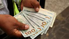 A money changer holds U.S. dollar bills at a street in downtown Lima, Peru, December 15, 2017. REUTERS/Mariana Bazo