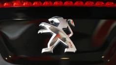 A Peugeot logo is seen on a car which is displayed at PSA Peugeot Citroen headquarters in Paris April 14, 2014. REUTERS/Benoit Tessier